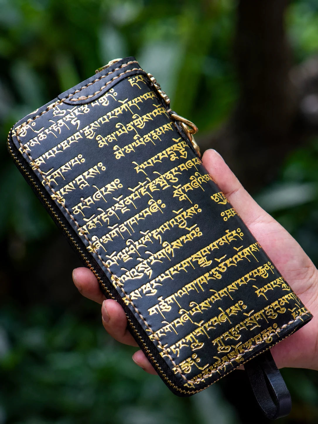 back view of black Tibetan script leather wallet in hand
