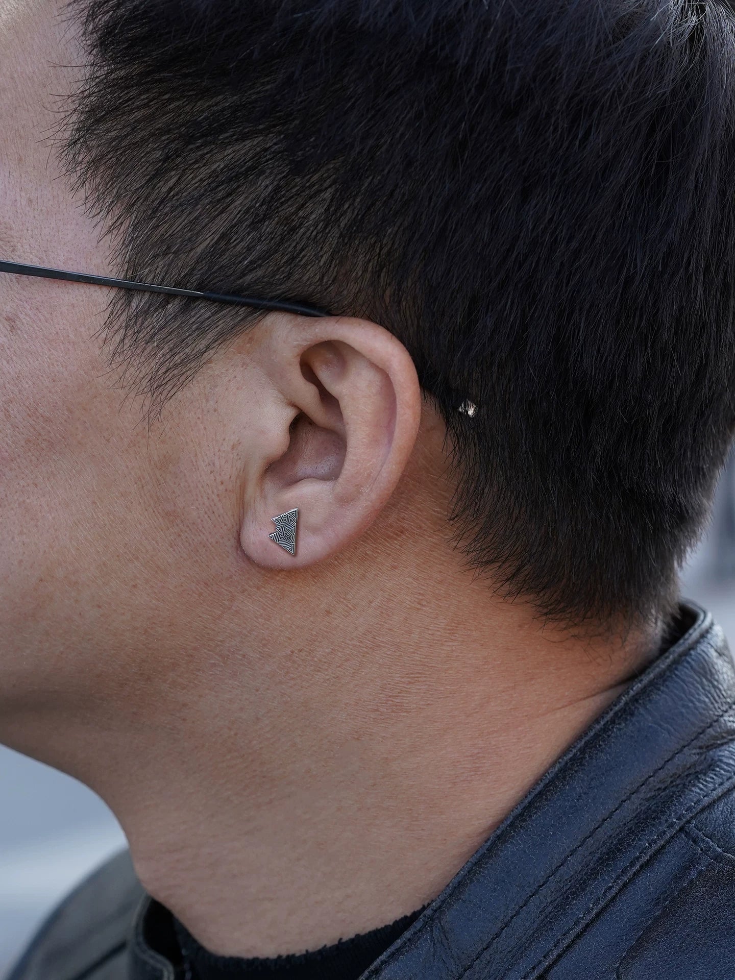 Left ear wearing view of triangle sterling silver biker earring