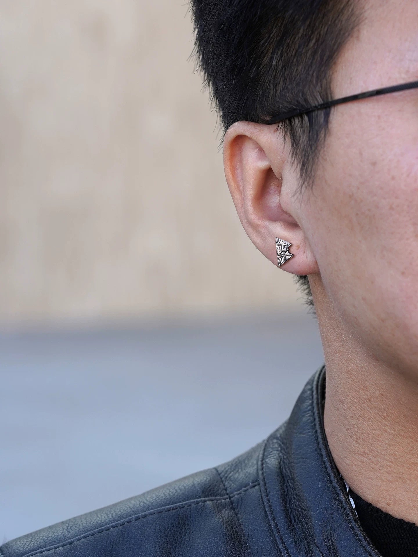 Right ear wearing view of triangle sterling silver biker earring