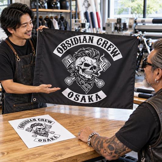 Designer presenting a finished custom exchange flag to a motorcycle club rider.