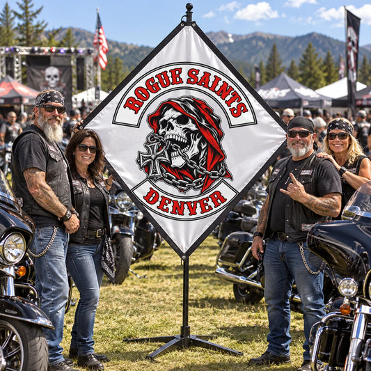 A motorcycle club rally crew displays a custom diamond flag beside parked American V-twin touring motorcycles.