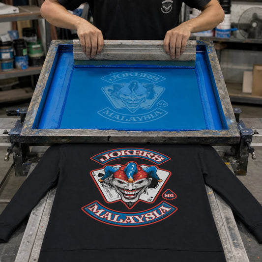 Motorcycle club artwork being screen printed onto a black custom long-sleeve shirt.