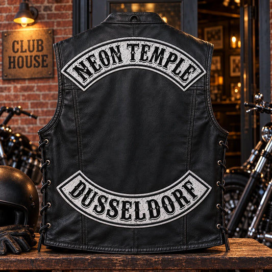Motorcycle club member wearing newly created top and bottom rocker patches outside a clubhouse.