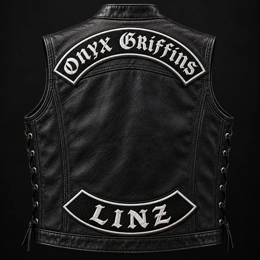 Complete leather motorcycle vest showing specialty embroidered top and bottom rockers with metallic accents.