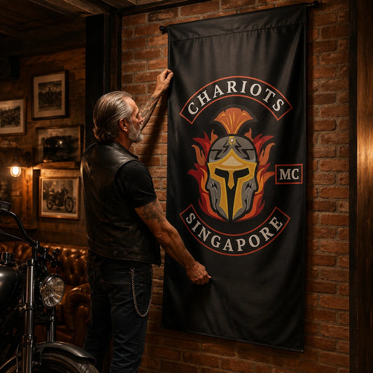 A mature rider mounts a custom vertical motorcycle club flag on the brick wall of a chapter room.