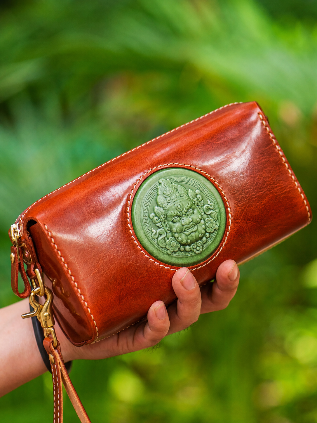 reddish brown wealth guardian leather biker clutch wallet held in hand
