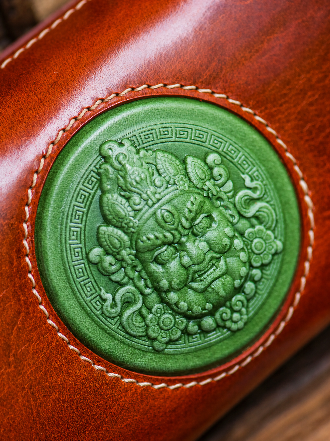 green wealth guardian medallion and top-grain leather close-up