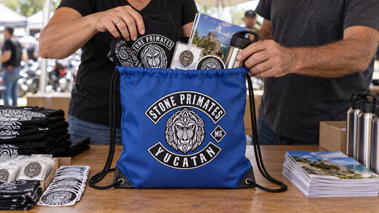 Chapter volunteers pack motorcycle rally registration items into a custom club-logo drawstring bag.